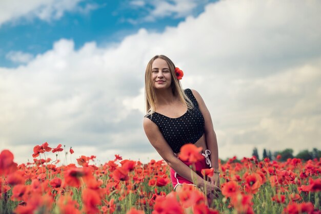 Młoda kobieta sama na mak w letni dzień pola