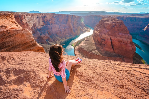 Młoda Kobieta Siedzi Na Krawędzi Klifu Z Widokiem Na Horseshoe Bend W Page Arizona