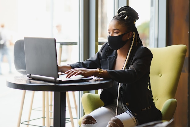 Młoda kobieta siedzi w kawiarni pracuje na laptopie
