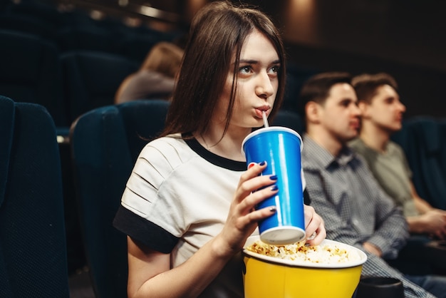 Młoda Kobieta Siedzi W Kinie Z Napojem I Popcornem. Czas Na Seans, Oglądanie Filmów