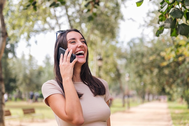 Młoda kobieta śmieje się podczas rozmowy z jej telefonem