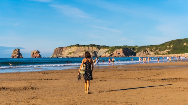 Młoda kobieta spacerująca po plaży w Hendaye, francuski kraj Basków