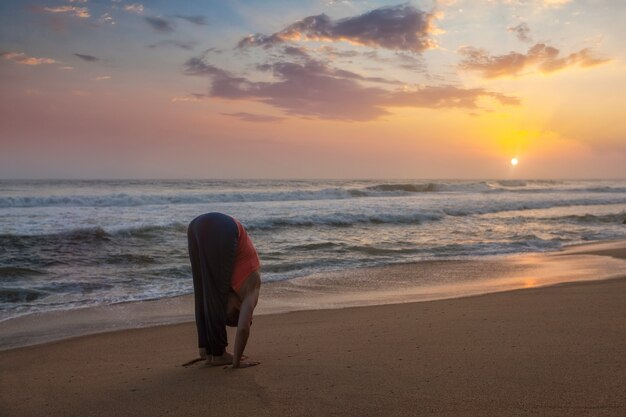 Młoda kobieta sportowy sprawny robi joga Powitanie słońca Surya Namaskar