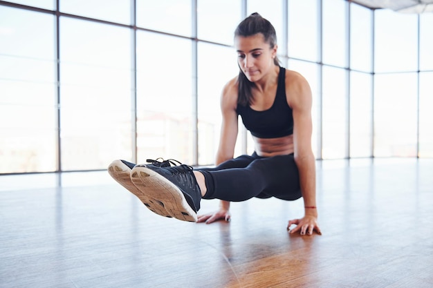 Młoda kobieta sportowy w odzieży sportowej robi fitness na siłowni.