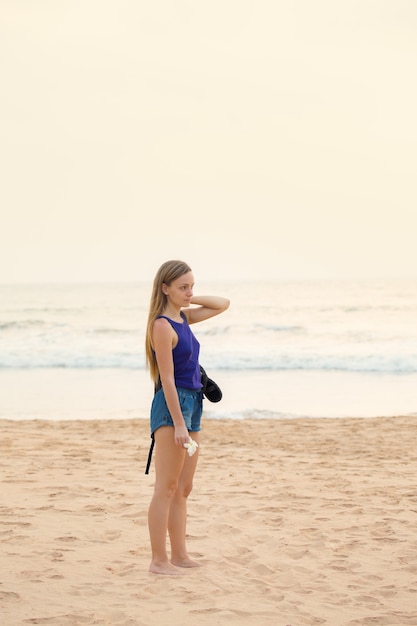 Młoda kobieta stoi na plaży w pobliżu oceanu