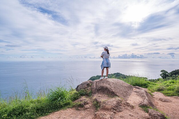 Młoda kobieta stoi na szczycie góry i patrzy na morze Phuket Tajlandia