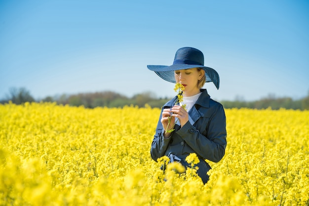 Młoda kobieta stoi w polu rzepaku