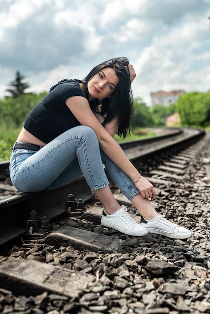 Młoda kobieta stojąc na kolei, podróż pociągiem w letnie wakacje.