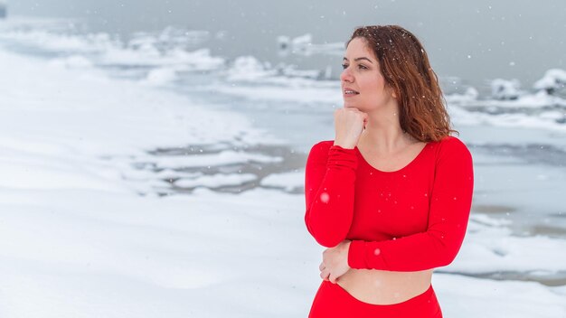 Zdjęcie młoda kobieta stojąca na pokrytym śniegiem polu