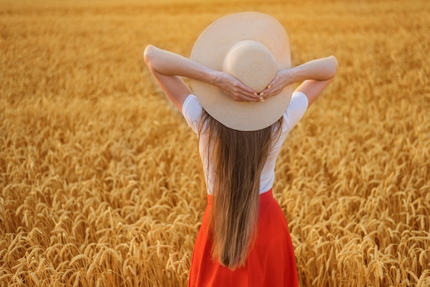 Młoda kobieta stojąca na polu pszenicy