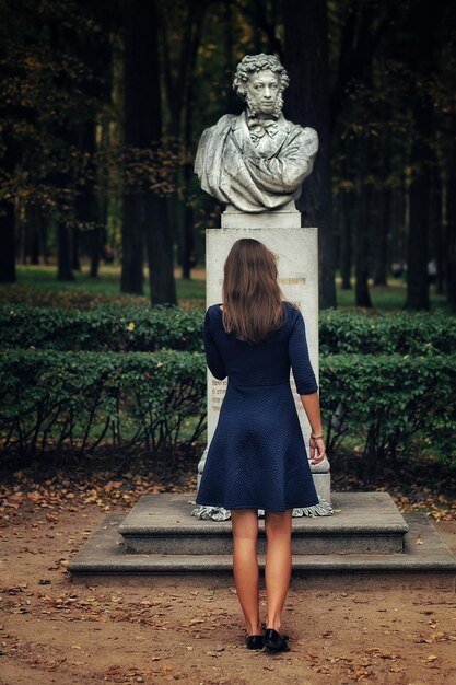 Zdjęcie młoda kobieta stojąca przed posągiem