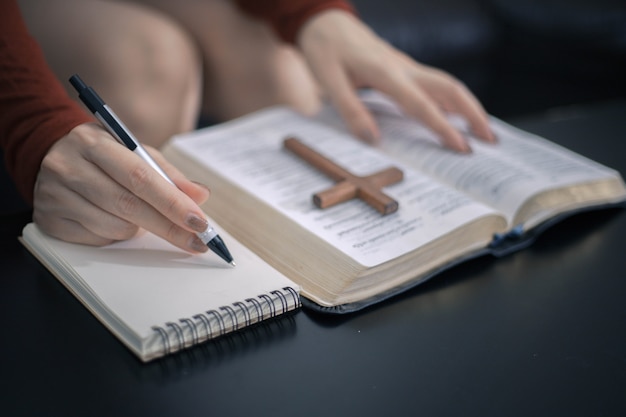 Młoda Kobieta Studiuje Biblię Z Krzyżem