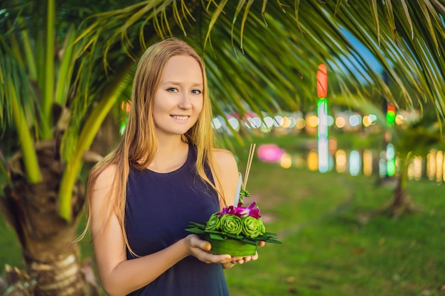 Młoda kobieta świętuje Loy Krathong Biega po wodzie Festiwal Loy Krathong Ludzie kupują kwiaty i świece, aby zapalić i unosić się na wodzie, aby uczcić festiwal Loy Krathong w Tajlandii