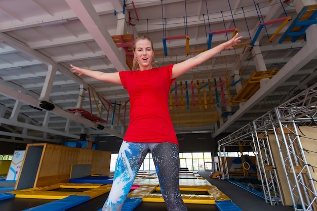 Młoda kobieta szczęśliwa skoki na trampolinie w pomieszczeniu.