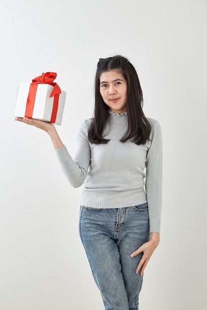 Młoda kobieta szczęśliwy chwyta prezenta pudełko w rękach
