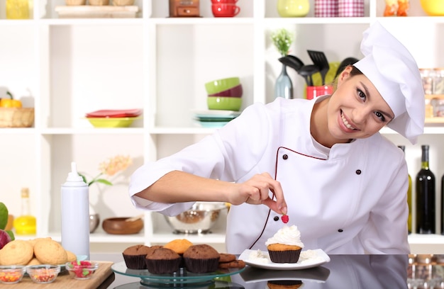 Zdjęcie młoda kobieta szefa kuchni kucharstwa tort w kuchni
