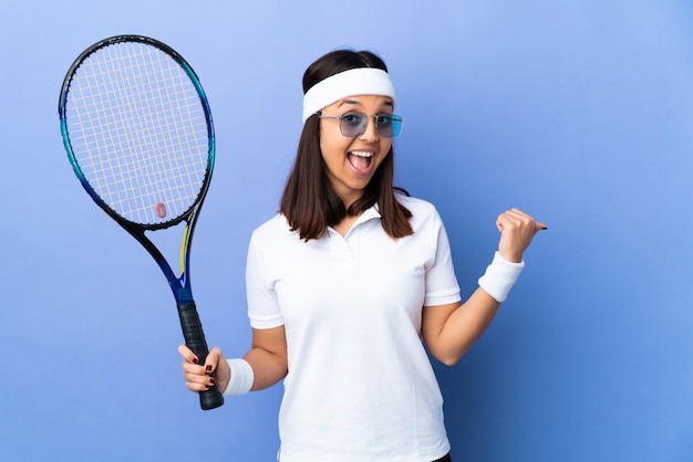 Młoda kobieta tenisistka na pojedyncze wskazując na bok, aby przedstawić produkt