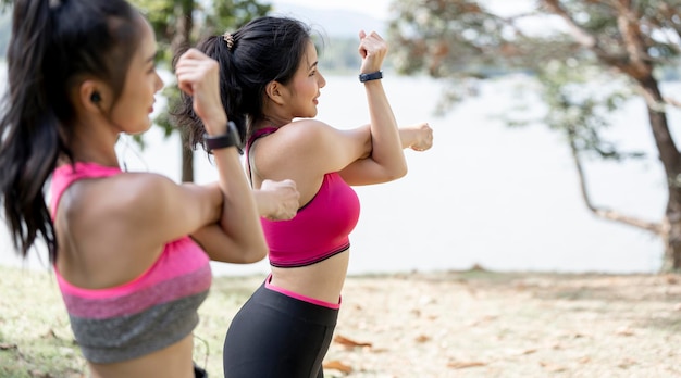 Młoda kobieta trening przed treningiem fitness w parku Zdrowa młoda kobieta rozgrzewa się na zewnątrz, rozciąga ramiona i odwraca wzrok