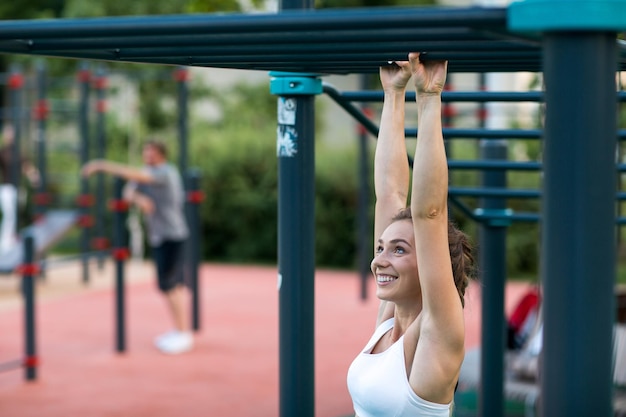 Młoda Kobieta Trenuje Na Placu Zabaw I Podciąga Się Na Drążku. Siłownia Treningu Fitness Na świeżym Powietrzu.