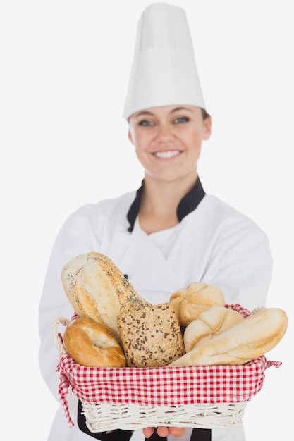 Młoda kobieta trzyma chlebowego kosz w szefa kuchni mundurze
