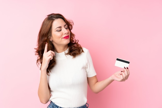 Młoda kobieta trzyma kartę kredytową