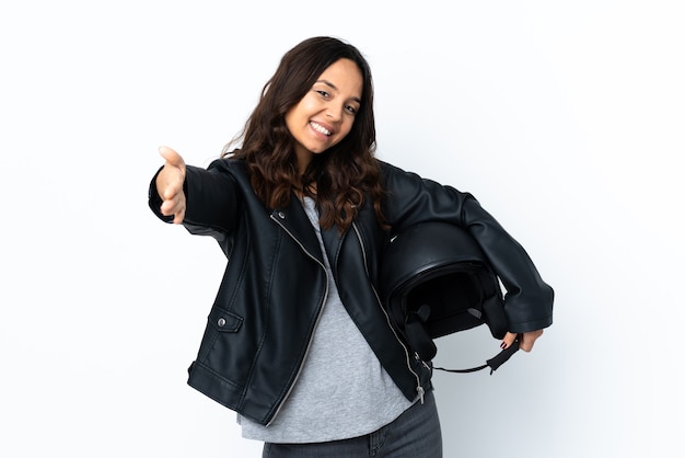 Młoda kobieta trzyma kask motocyklowy na pojedyncze białe ściany, prezentując i zapraszając do przyjścia z ręką