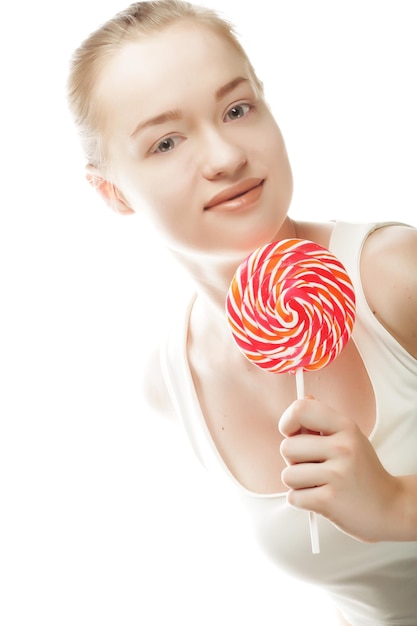 Młoda kobieta trzyma lolly pop na białym tle