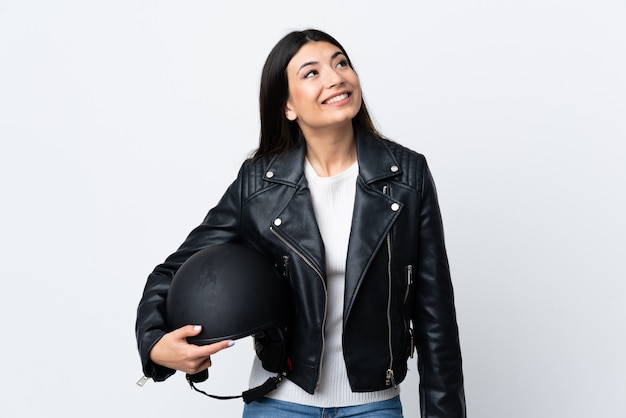 Młoda kobieta trzyma motocyklu hełm nad odosobnionym białym śmia się i przyglądającym up