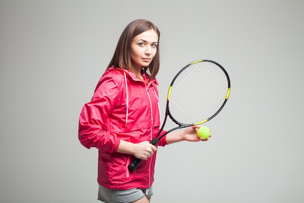 Młoda kobieta trzyma rakietę tenisową