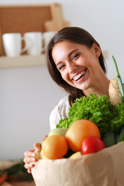 Młoda kobieta trzyma torbę na zakupy spożywcze z warzywami