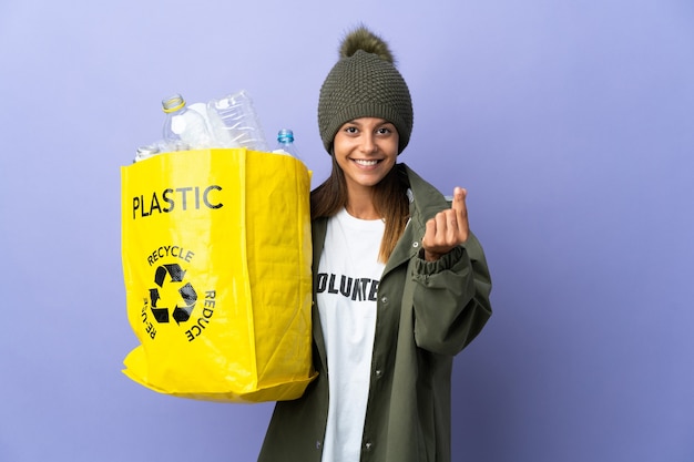 Młoda kobieta trzyma torbę pełną plastiku zarabianie gestem