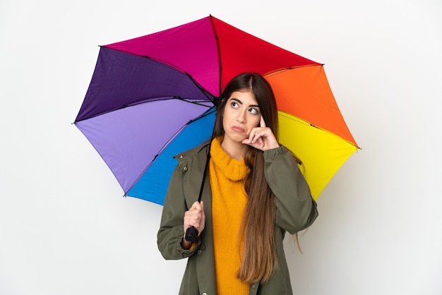 Młoda kobieta trzymająca parasolkę na białym tle myśląca o pomyśle