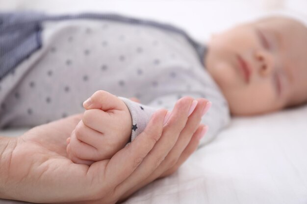 Młoda kobieta trzymająca się za rękę słodkiego śpiącego dziecka zbliżenie