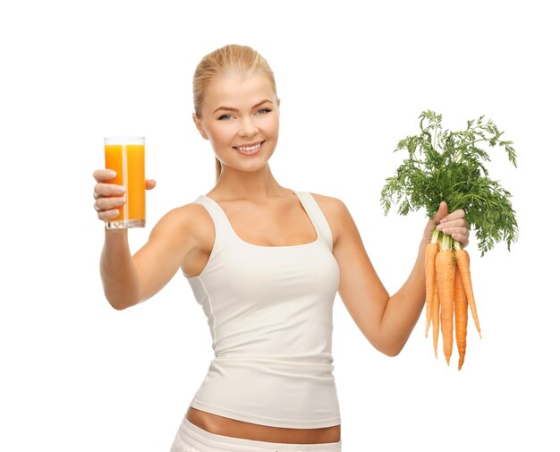 młoda kobieta trzymająca szklankę soku i marchewki
