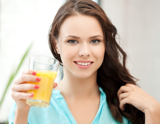 młoda kobieta trzymająca szklankę soku pomarańczowego