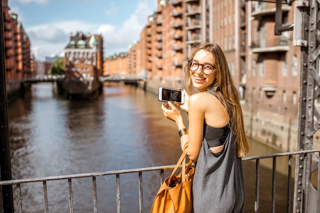 Młoda kobieta turysta fotografująca piękny widok na Speicherstadt, zabytkowej dzielnicy magazynowej w Hamburgu, Niemcy