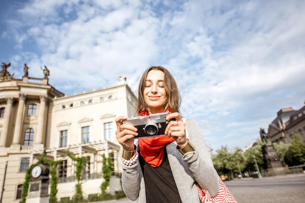 Młoda kobieta turysta spacerująca z aparatem fotograficznym przed starą biblioteką w Berlinie
