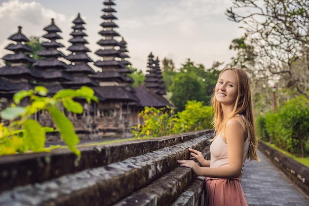 Młoda kobieta turystyczna w tradycyjnej balijskiej świątyni hinduskiej Taman Ayun w Mengwi. Bali, Indonezja