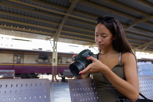 Młoda Kobieta Turystycznych Siedzi I Za Pomocą Aparatu Dslr