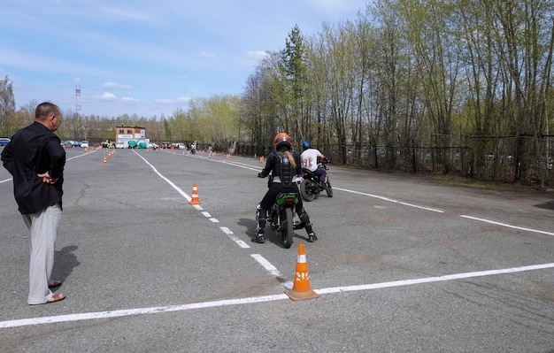 Młoda kobieta uczy się jeździć na motocyklu w szkole motocyklowej.