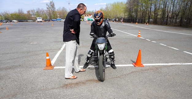 Zdjęcie młoda kobieta uczy się jeździć na motocyklu w szkole motocyklowej.