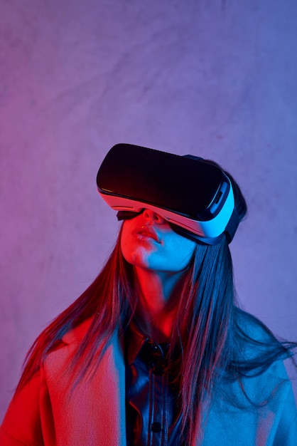 Młoda kobieta używa hełm rzeczywistości wirtualnej podczas gdy będący ubranym żakiet