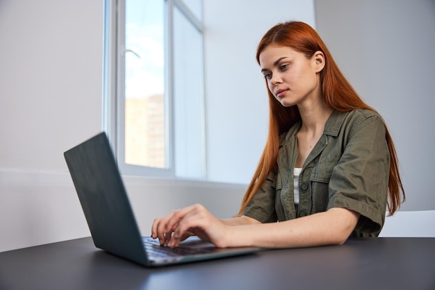 Młoda kobieta używająca laptopa na stole
