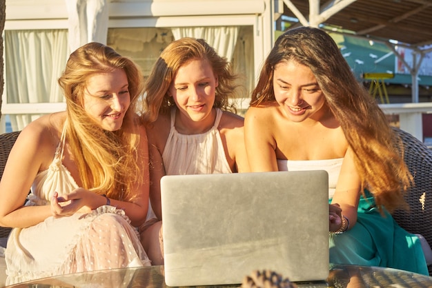 Młoda kobieta używająca laptopa siedząc na krześle