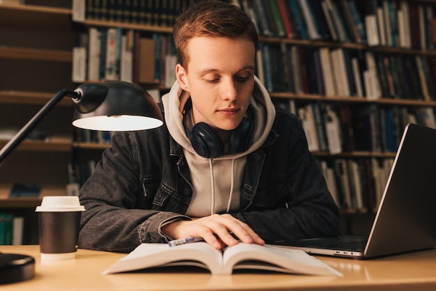 Młoda kobieta używająca laptopa w bibliotece