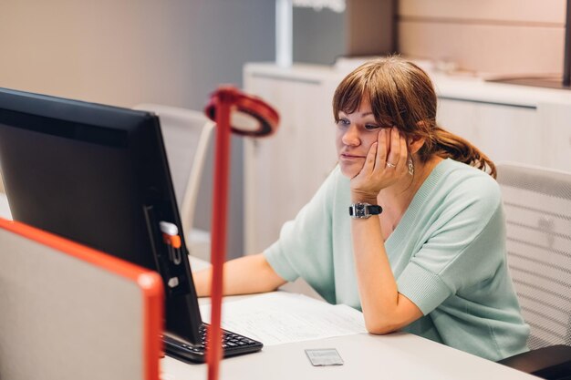 Młoda kobieta używająca laptopa w biurze