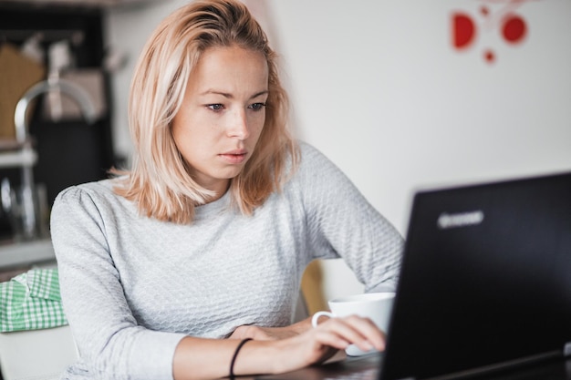 Zdjęcie młoda kobieta używająca laptopa w domu