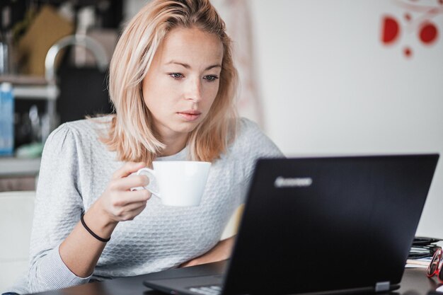 Zdjęcie młoda kobieta używająca laptopa w domu