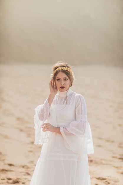 młoda kobieta w białej sukni spacerująca po plaży