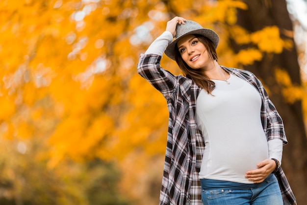Młoda kobieta w ciąży w jesiennym parku